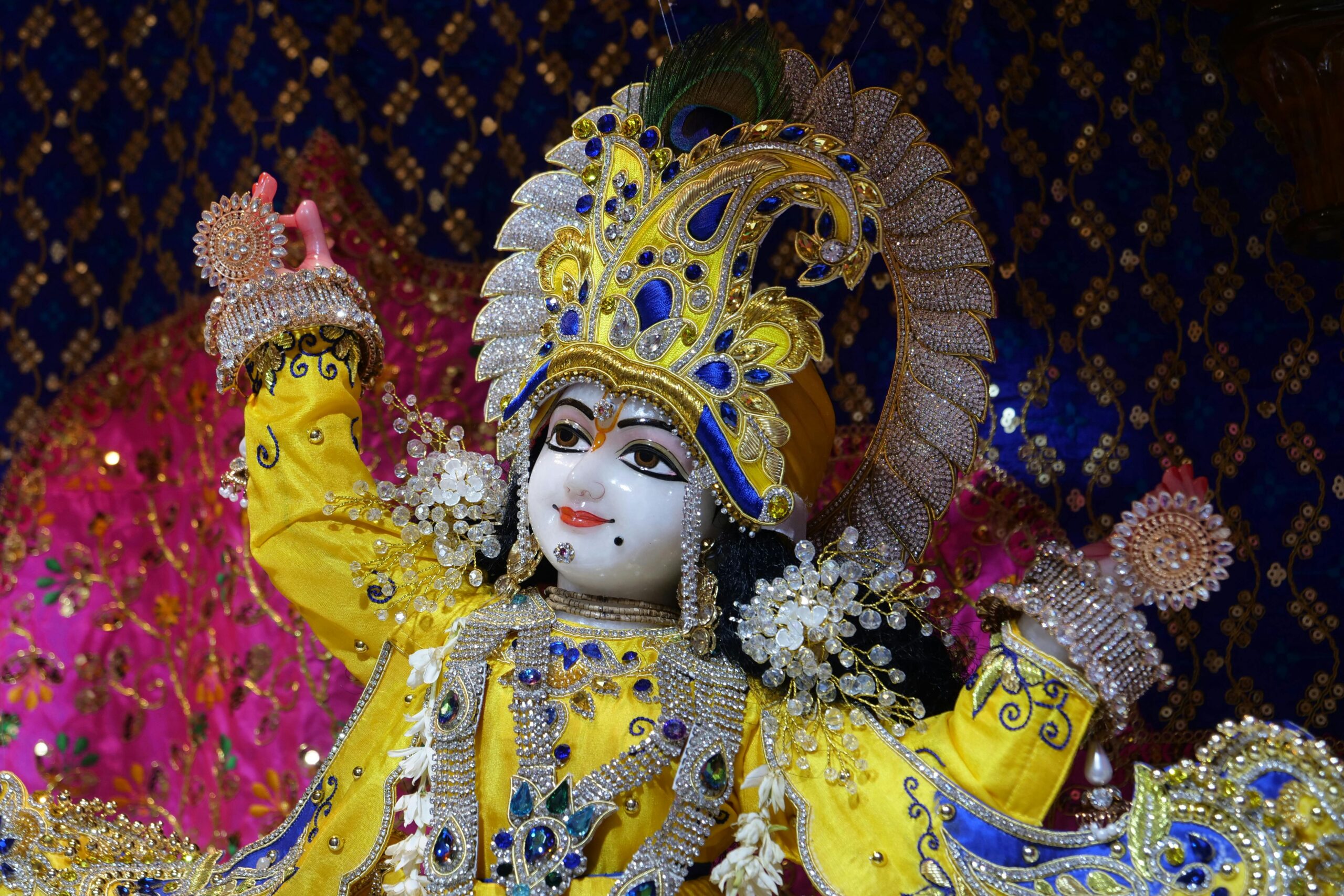 Beautifully adorned Krishna sculpture in a Hindu temple, showcasing traditional craftsmanship.