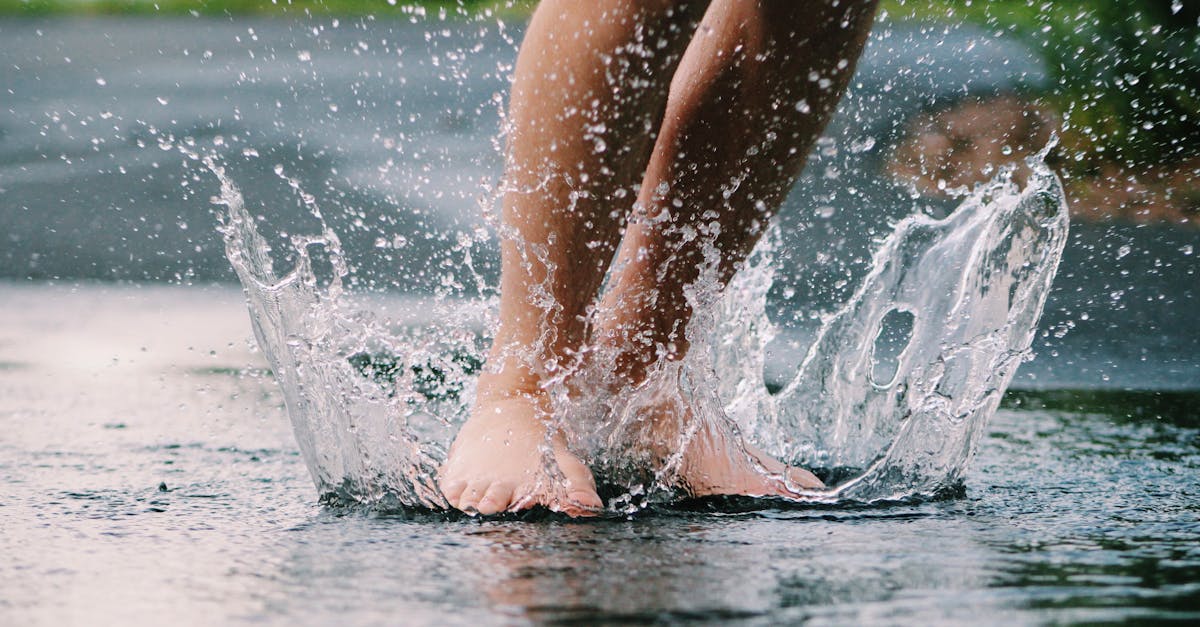 Bare feet splashing in a puddle, capturing the joy of a rainy day outdoors.